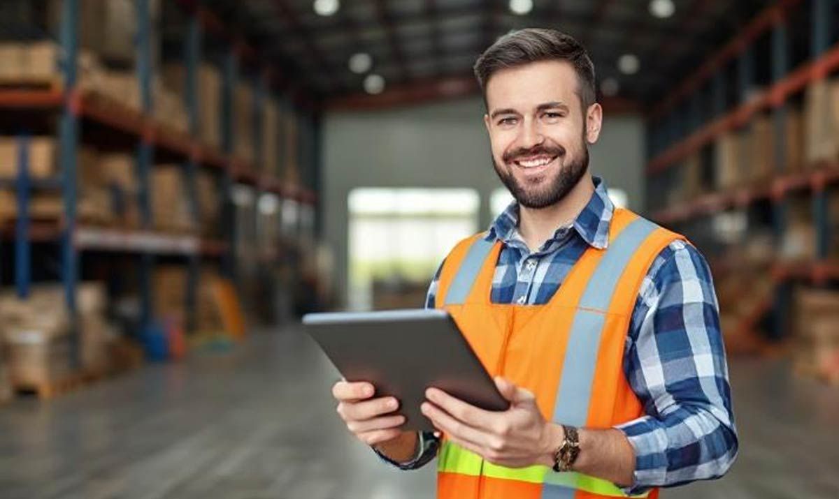 man-standing-in-warehouse-holding-a-tablet