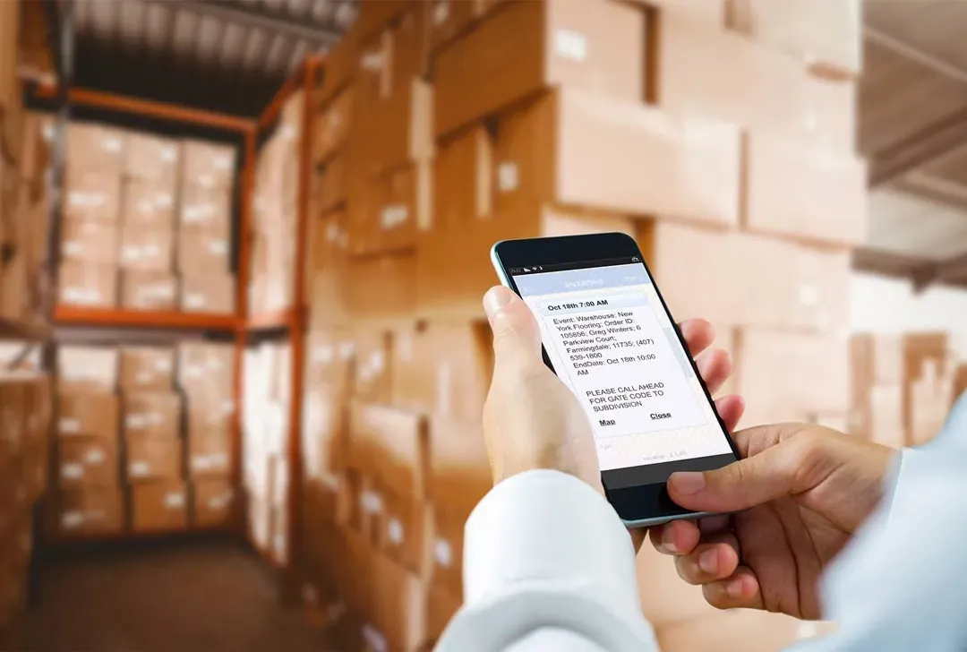 Employees collaborating in a flooring warehouse using digital tools for inventory management